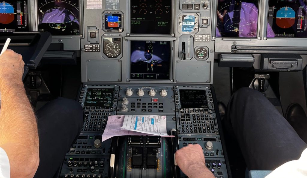 Airbus A320 cockpit view with sidestick and primary flight displays in cruise