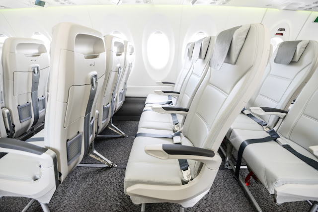 airBaltic Airbus A220-300 economy cabin showing modern slimline seats used for Air Serbia wet-lease